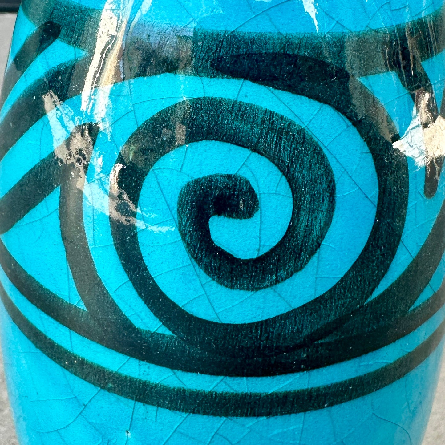 Détail de la frise spiralée noire sur vase Art nouveau en céramique émaillée bleue craquelée
